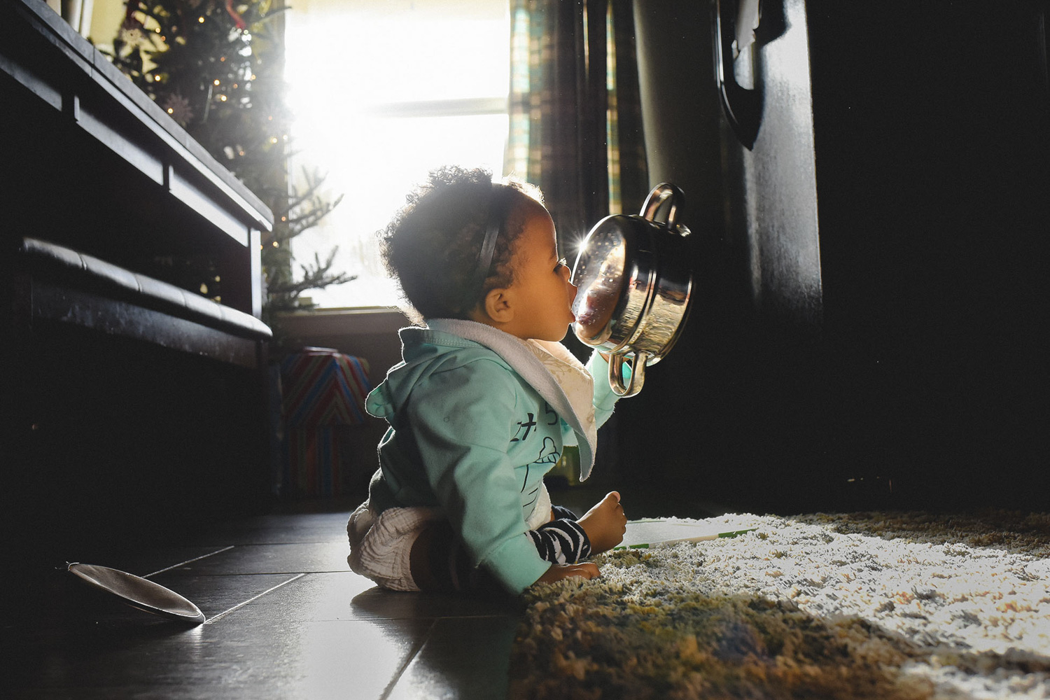 Baby lit by a window near the Christmas tree
